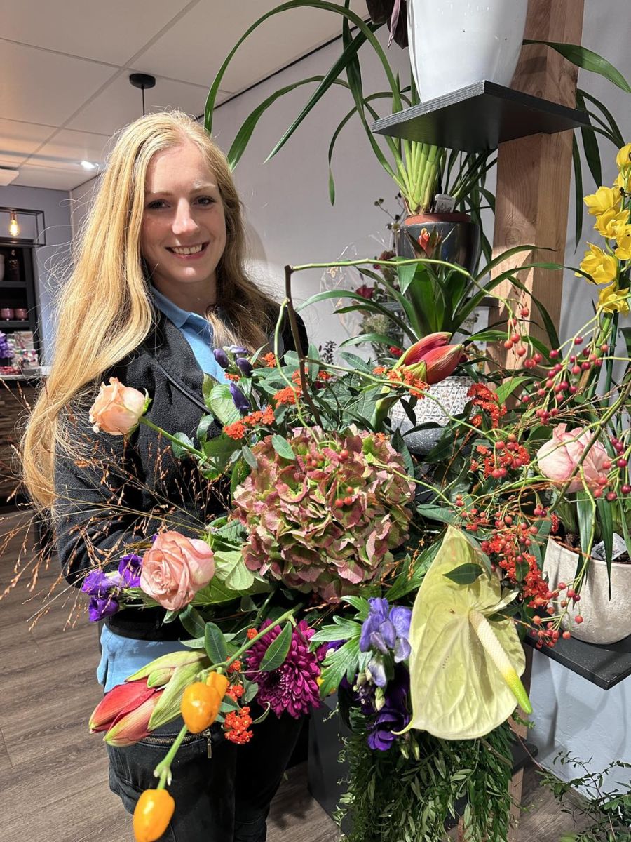 Medewerker met een plukboeket in herfstsferen