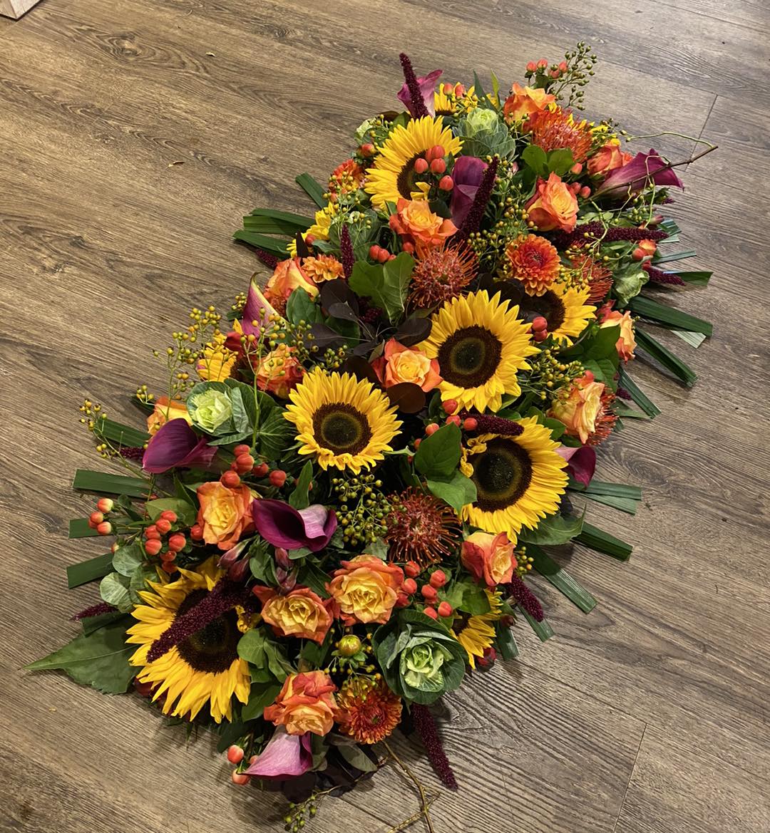 Kistbedekking rouwbloemstuk geel oranje paars Mies Bloemen